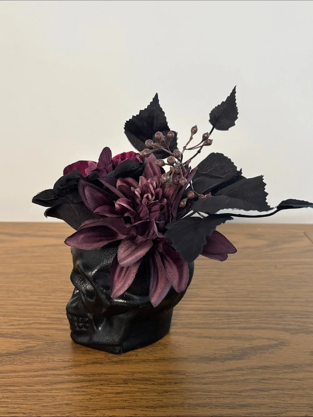 Black Skull Vase with Dark Purple Floral Arrangement